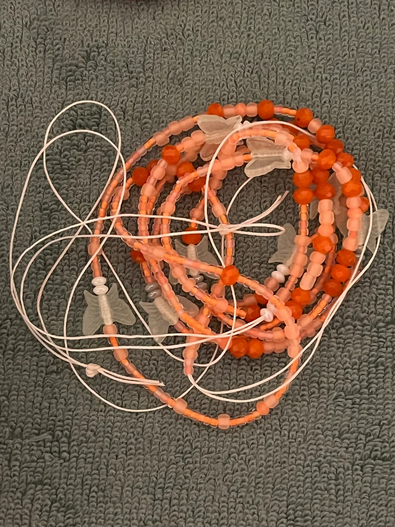 Orange waist bead with glow in the dark butterflies on there 50 inches long tie on