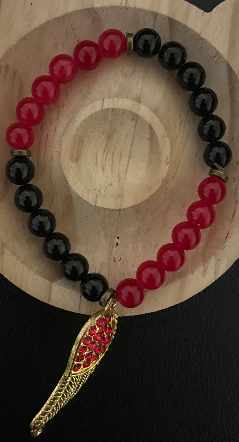 Red and black bracelet with a feather charm